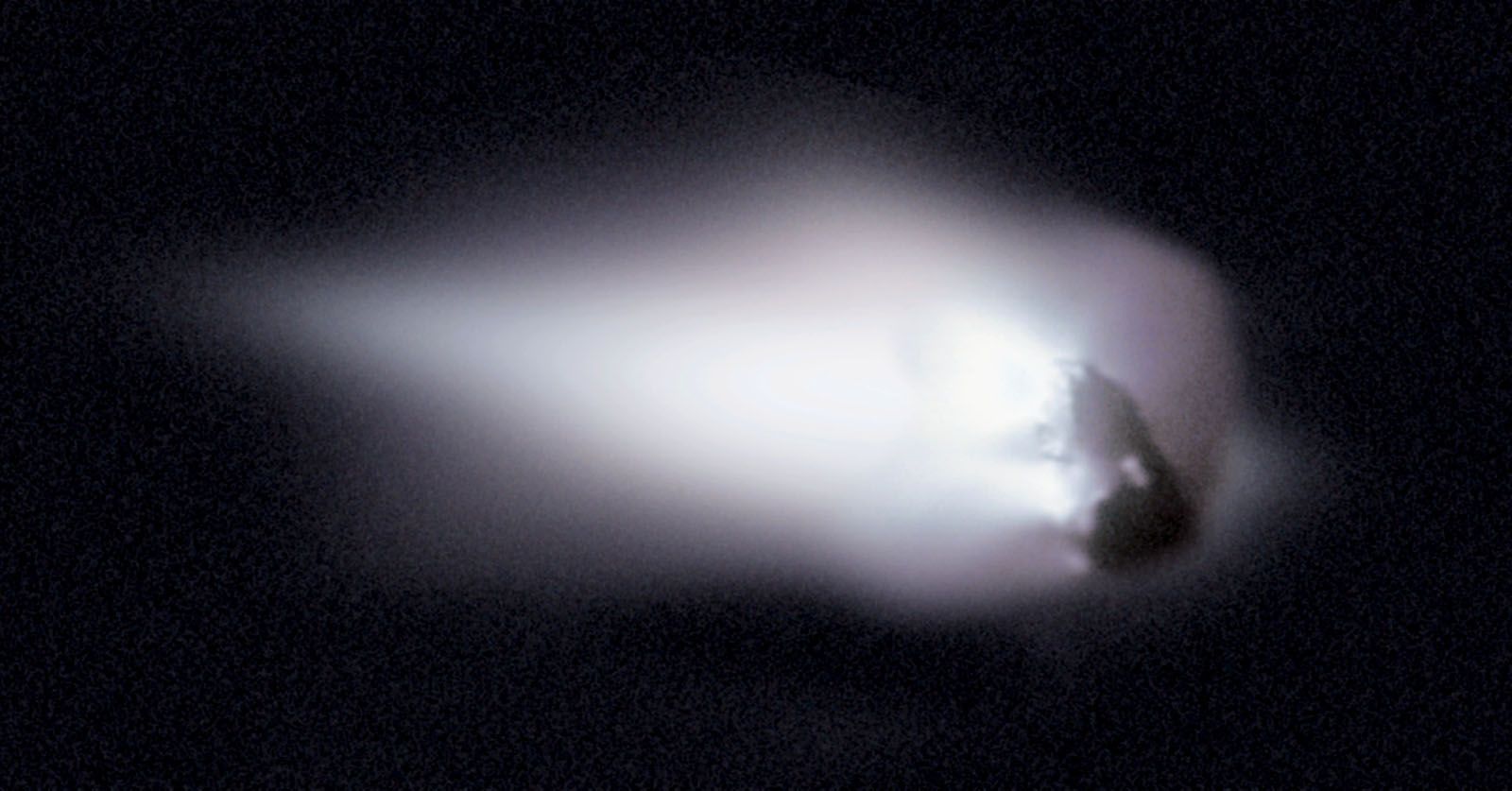 This view of comet Halley's nucleus was obtained by the Halley Multicolour Camera (HMC) on board the Giotto spacecraft, as it passed within 600 km of the comet nucleus on March 13, 1986. a large white coma is visible around a peanut shaped rock.