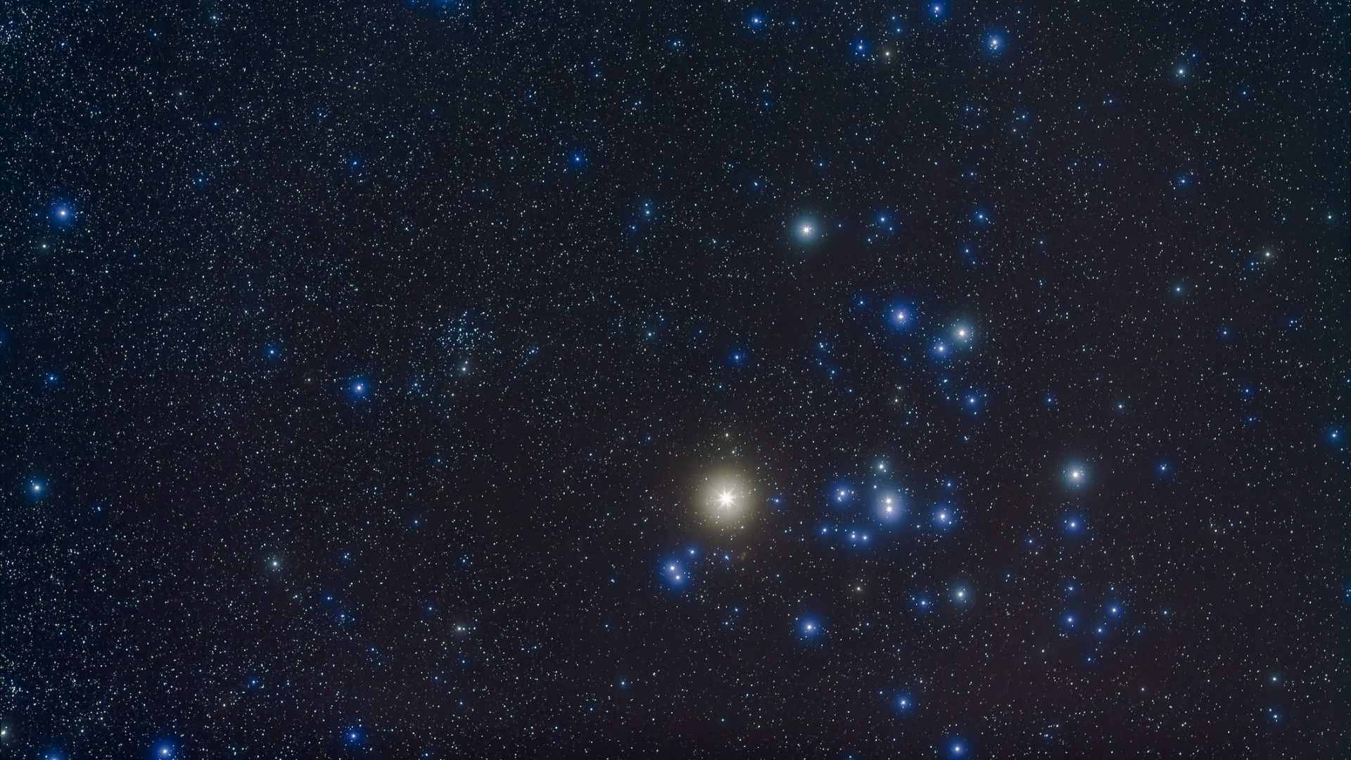 Photo of the night sky showing the open cluster Hyades and giant star Aldebaran in the constellation of Taurus, with smaller open cluster NGC 1647 at left.
