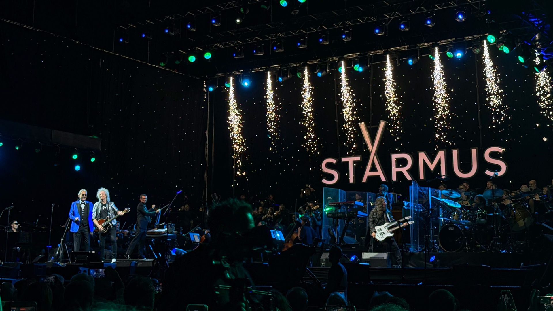 stage with musicians and the word starmus written at the back. left is Borcelli, then Brian May and on the right Ron 'bumblefoot' Thal