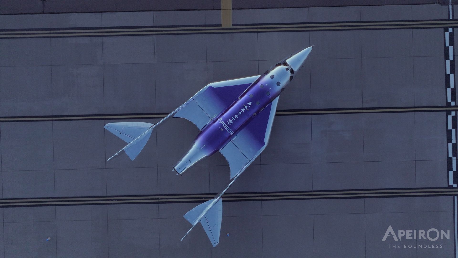 A space plane seen from above sitting on a runway.