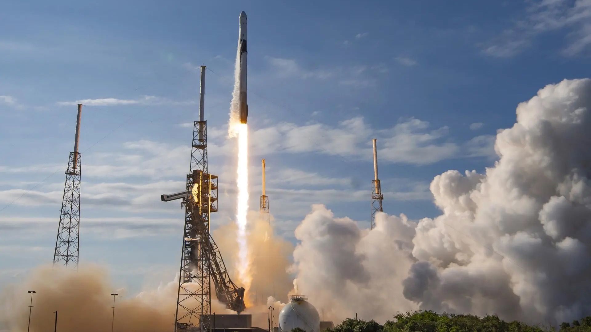 a black and white rocket launches into a blue sky