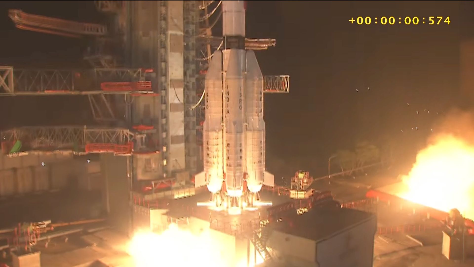 close-up photo of the bottom half of a white rocket launching at night